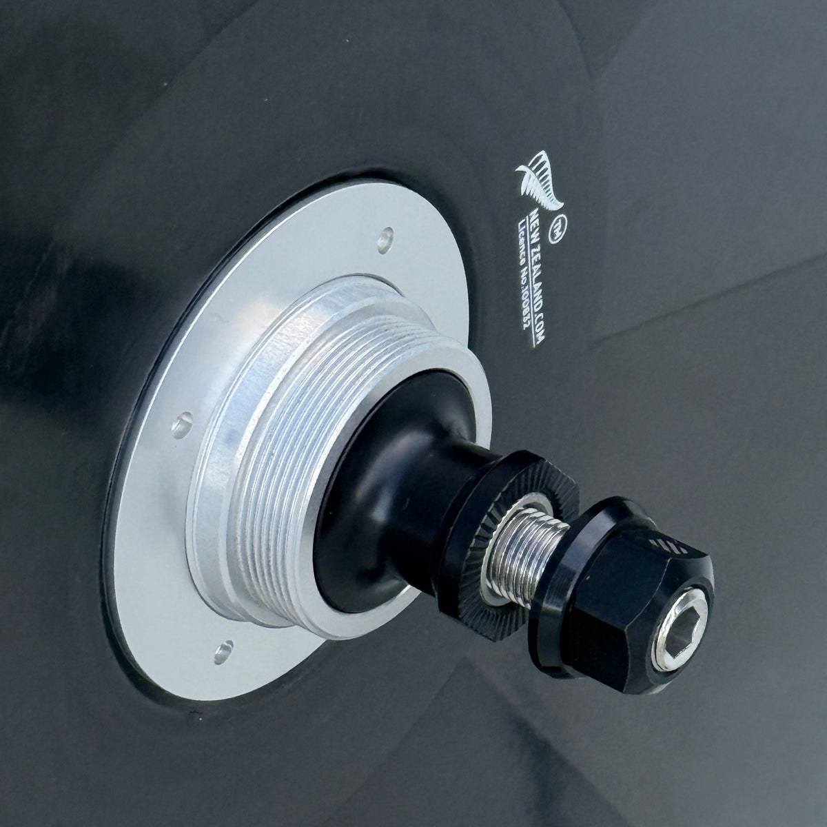 Close-up of a black carbon disc wheel with a silver and black hub,  and a white silver fern logo.